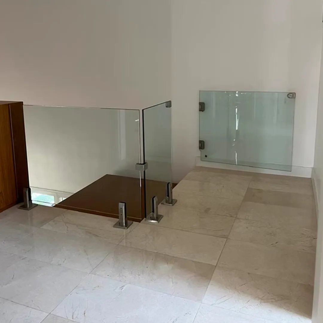Moderna baranda con paños de vidrio transparente y soportes de acero inoxidable